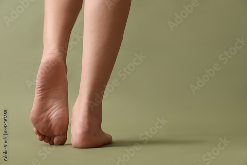 Female barefoot legs on color background