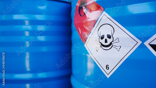 Flammable, acid, volatile, warning labels, mounted on hazardous chemical storage tanks in the warehouse of a chemical industrial factory plant. Waiting for delivery according to the user's order.