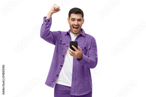 Happy excited sucessful modern man holding phone and raising arm up to celebrate achievement