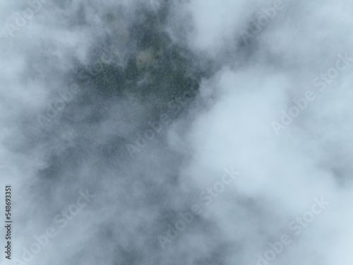 Rainy weather in mountains. Misty fog blowing over pine tree forest. Aerial footage of spruce forest trees on the mountain hills at misty day. Morning fog at beautiful forest. 