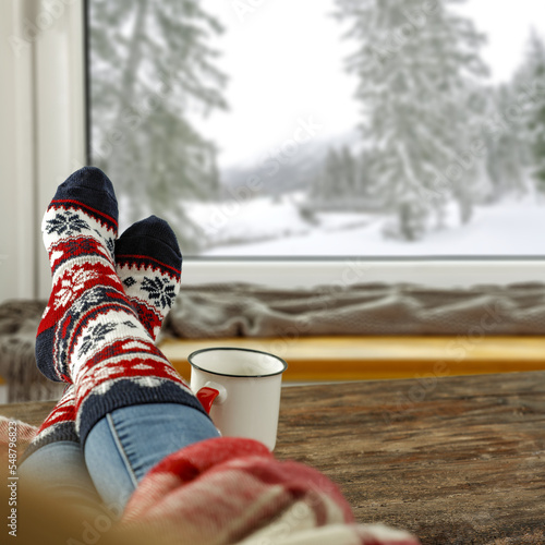 Woman legs and winter window background. 