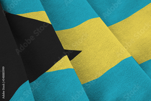 Bahamas flag with big folds waving close up under the studio light indoors. The official symbols and colors in banner