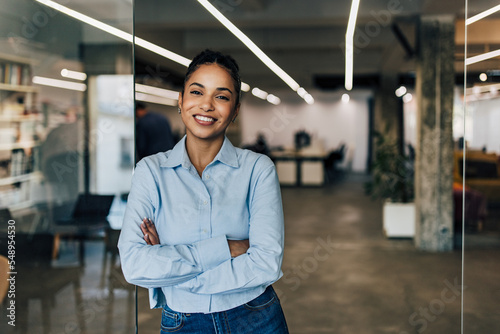 Smilling businesswoman standing at the office,looking at the camera.