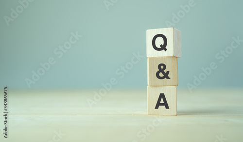Q and A - an abbreviation of wooden blocks with letters on a gray background. Illustration for frequently asked questions concepts in websites, social networks, business pages. Business concept.