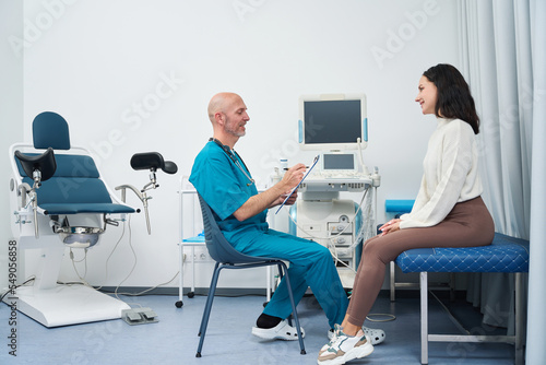 Doctor listens and writes down medical history of patient during consultation