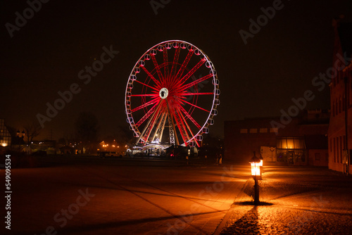 Ferris wheel in the old town of Gdansk. View of Motlawa River and Ferris wheel with water reflection in Old Town of Gdansk at night, Poland