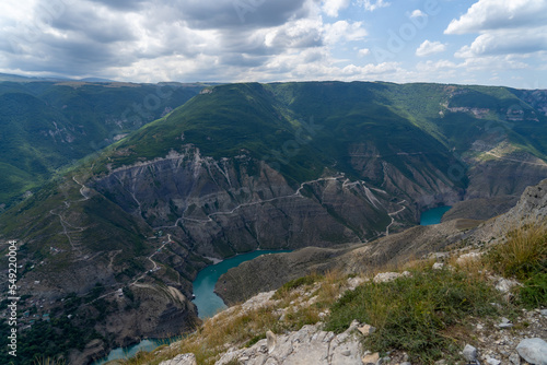 Turquoise river Sulak meandering through rocky forested landscape. Winding turquoise Sulak River in crevice in mountains of Dagestan at summer. Natural canyon in mountains Dubki