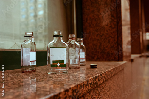 Many small glass bottles near window outdoors