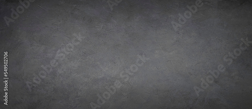 Black concrete background. The texture of concrete. Horizontal view, panoramic.