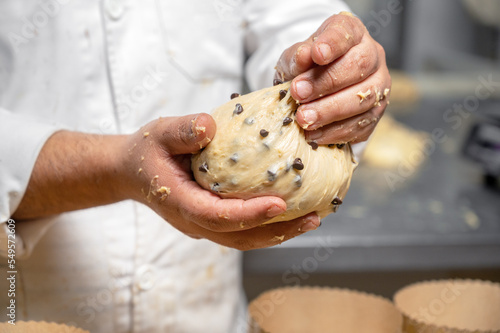 Artisan italian baker putting panettone christmas cake dough into molds. High quality photography