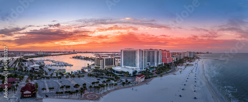 Row of hotels line Clearwater beach near Tampa with white sand colorful sunrise sky