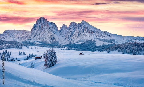 Untouched winter landscape. Frosty winter view of Alpe di Siusi village with Plattkofel peak on background. Stunning sunrise in Dolomite Alps, Ityaly, Europe. Beauty of nature concept background..