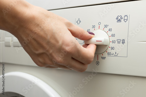 a man chooses a mode on a washing machine