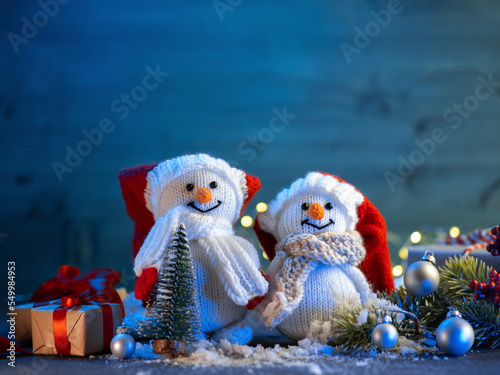 Cute pair of Christmas knitted snowmen on the festive table copy space