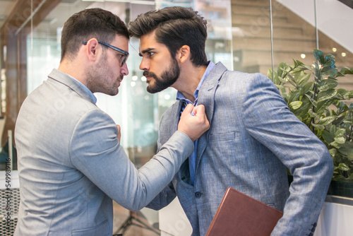 Business conflict between two business men in formal-wear in office. Boss and employee with aggressive expression fight.