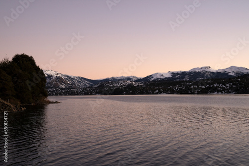 Magical view of the calm lake and mountains at sunset. Beautiful dusk colors in the landscape.