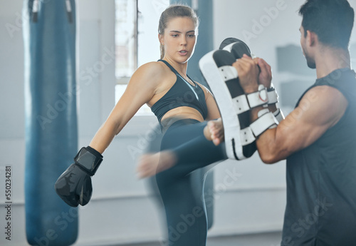 Active and fit sport woman training kickboxing with coach, learning kicking exercise and doing cardio fitness workout for wellness health at gym. Female kickboxer training with sports instructor
