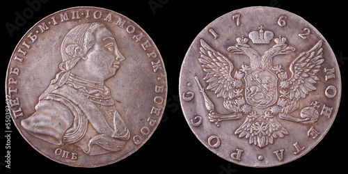 A Russian silver coin with a value of 1 ruble in 1762. Two sides of the coin on a black background. Isolated