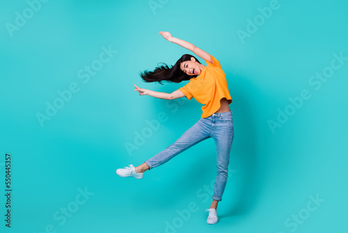 Full size photo of impressed brunette lady dance wear t-shirt jeans shoes isolated on turquoise color background