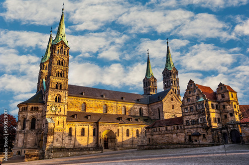 Der Bamberger Dom im warmen Abendlicht der Sonne mit aufgelockerter Bewölkung vor blauem Himmel