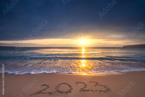 Happy New Year 2023 sea sunrise on the beach shore concept