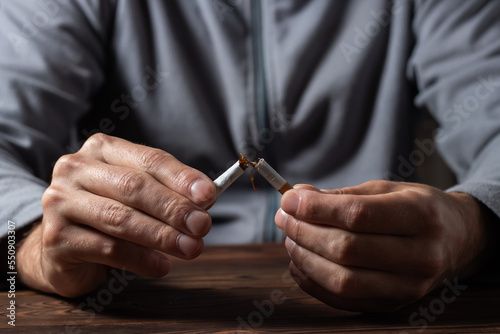 Cigarette. World No Tobacco Day Concept. Stop smoking cigarettes concept. Closeup man holding broken cigarette in hands