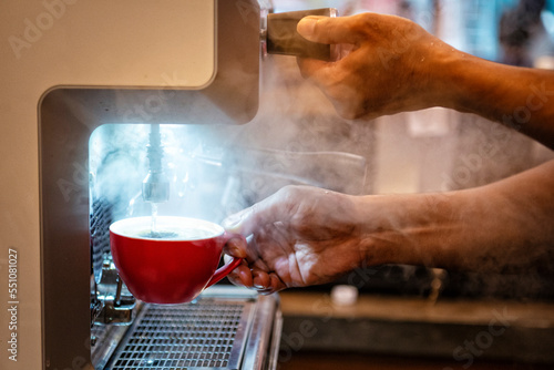 Barista parzy kawę w profesjonalnym ekspresie do kawy w kawiarni