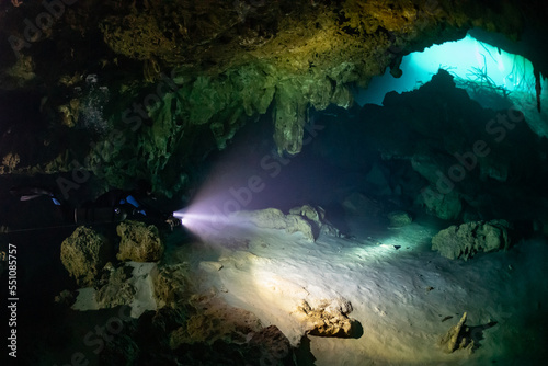 cave diver instructor leading a group of divers in a mexican cenote underwater