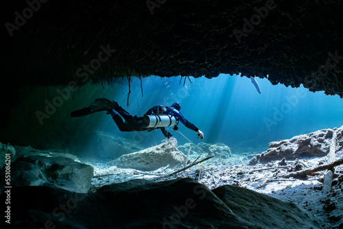 cave diver instructor leading a group of divers in a mexican cenote underwater