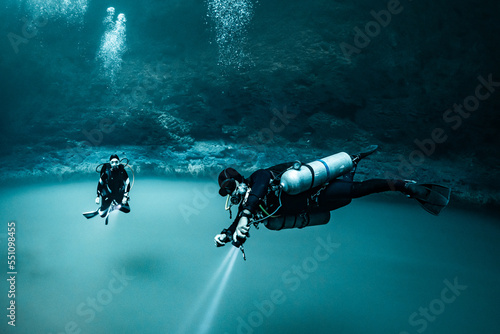 cave diver instructor leading a group of divers in a mexican cenote underwater