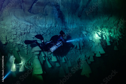 cave diver instructor leading a group of divers in a mexican cenote underwater