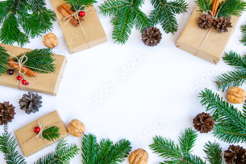 Gałązki jodły, prezenty i naturalne ozdoby na białym tle. Bożonarodzeniowe tło.