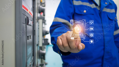 Senior Engineer is using hand to scan finger by touching holographic screen for lock-in to access control system of industrial factory. industrial works, innovation, and future technology concept