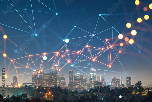 Illuminated Skyline panorama of Los Angeles downtown at night, California, USA. Skyscrapers of LA city. Glowing Social media icons. The concept of networking and new connections between people