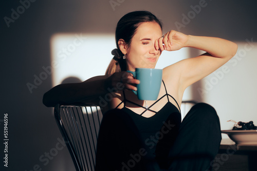 Sleepy Woman Rubbing her Eyes Having Coffee in the Morning. Somnolent girl feeling drowsy and tired all the time 