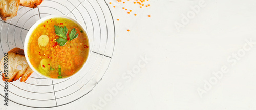 Bowl of tasty lentil soup on white background with space for text