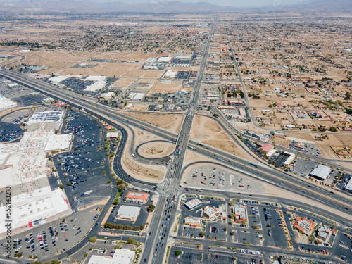 Victorville, California – April 15, 2021: aerial drone view of Victorville above freeway 15 and Bear Valley Rd with shopping malls, commercial buildings, vacant lands.