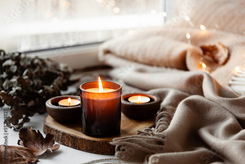 warm cozy window arrangement, winter or autumn concept, candles throw lights