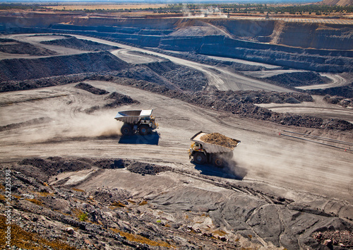 Two diesel-electric trucks used in modern mines and quarries for hauling industrial quantities of ore or coal. Used when extra torque is needed for steep hills. Blackwater, Australia. Logos removed. 