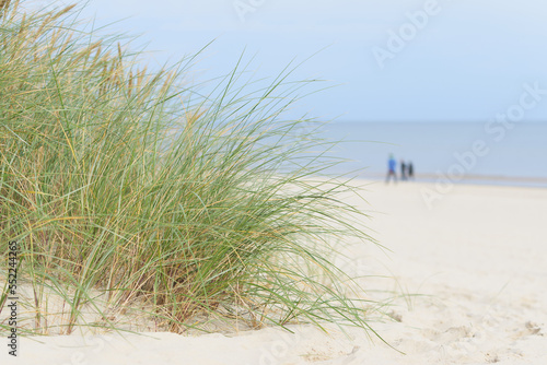 Strand bei Swinoujscie auf der Insel Usedom an der polnischen Ostseeküste. Im Hintergrund drei verschwommene Spaziergänger