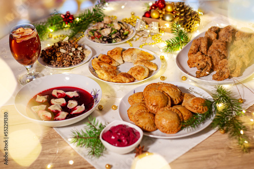 Barszcz czerwony z uszkami i pierogi na wigilijnym świątecznym stole. Polska tradycja na Boże Narodzenie.