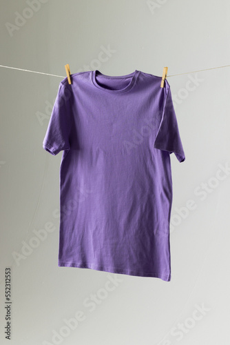 Close up of hanging purple tshirt and copy space on white background