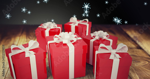 Image of snow falling over christmas presents on wooden and black background