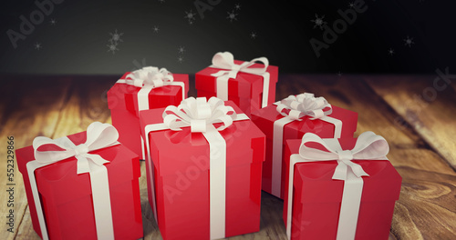Image of snow falling over christmas presents on wooden and black background