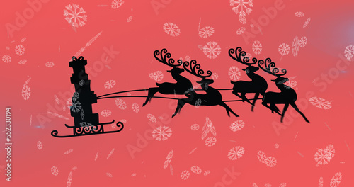Image of christmas presents in sleigh with reindeer over snow falling on red background
