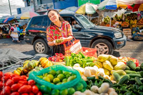 Mujer comprando vegetales frescos en un mercado local de Guatemala.