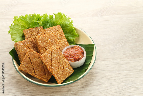 Tempeh, Tempe Goreng or Fried tempeh is Indonesia traditional food, made from fermented soybean seeds. Served with sambal (chilli sauce) 