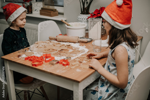Dzieci wycinają wzroki z ciasta na świąteczne ciastka dla mikołaja
