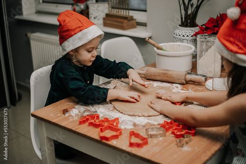 Dzieci wycinają wzroki z ciasta na świąteczne ciastka na wigilię