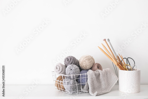 Handmade basket with neutral yarn for knitting and crochet. Knitting needles, hooks and scissors. Homey cozy atmosphere. copy space